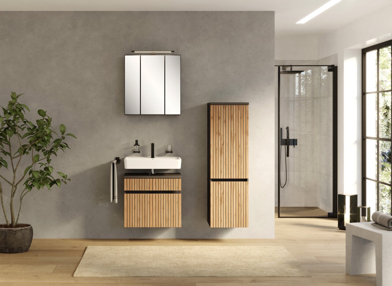 Moderner Waschbeckenunterschrank aus Holz mit vertikalen Lamellen, frontal betrachtet in einem stilvollen Badezimmer mit grauer Wand und Glasdusche.