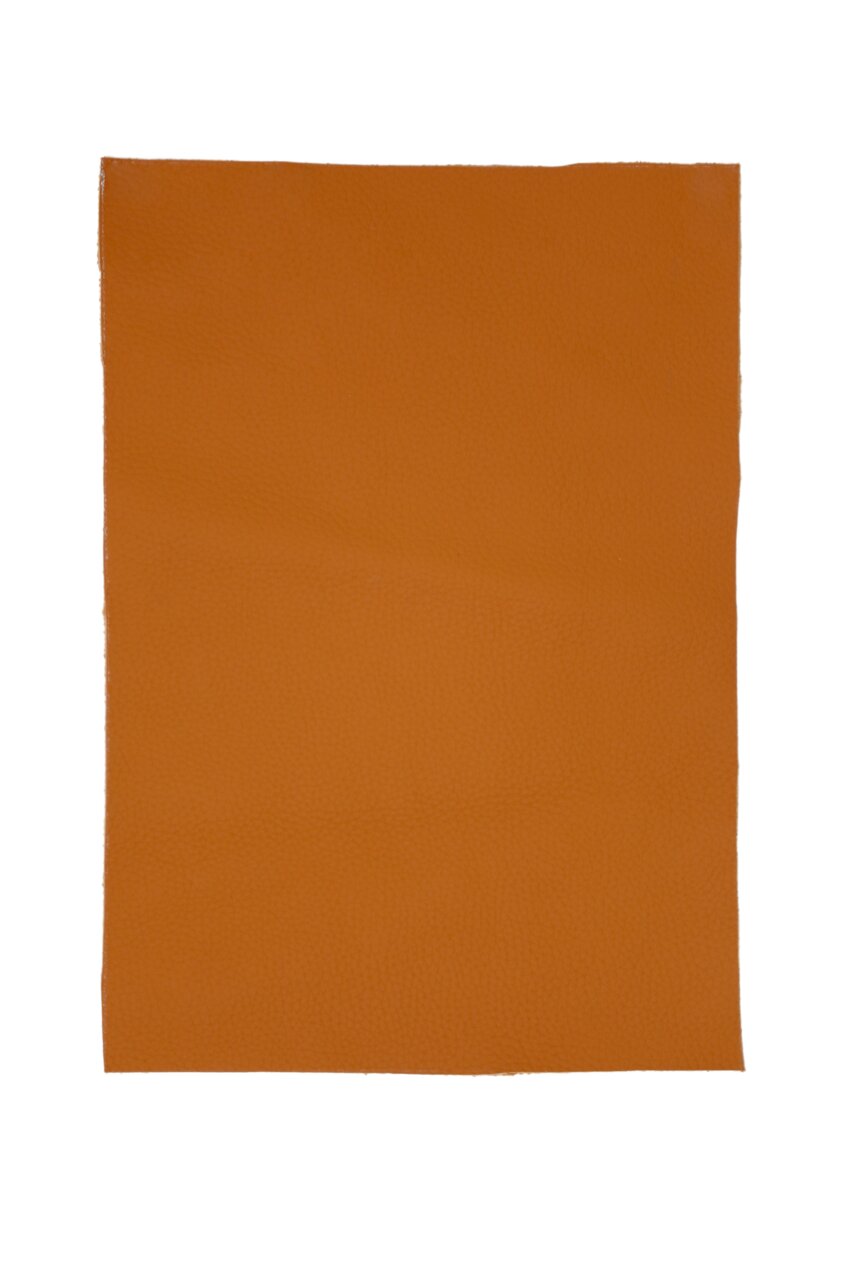Nahaufnahme eines rechteckigen, orangefarbenen Lederstücks, das als Material für einen Barhocker verwendet wird. Draufsicht.