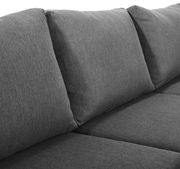 Nahaufnahme eines grauen Lounge-Sofas mit weichen Kissen, seitliche Perspektive