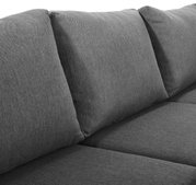Nahaufnahme eines grauen Lounge-Sofas mit weichen Kissen, seitliche Perspektive
