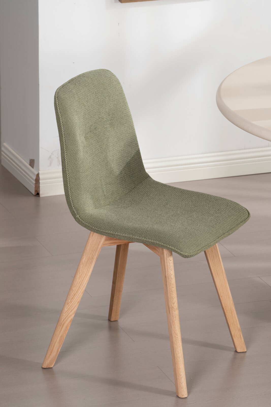 Moderne stoel met groene stoffen bekleding en houten poten, zijaanzicht