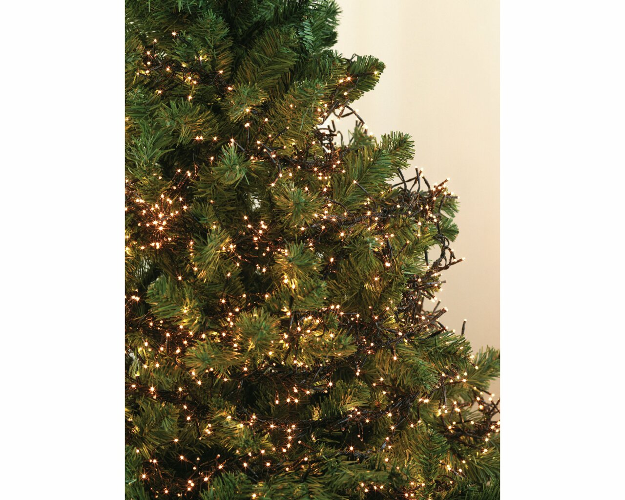 Nahaufnahme eines Weihnachtsbaums mit warmweißer LED-Clusterbeleuchtung, die gleichmäßig um die Zweige gewickelt ist.