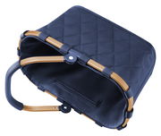 Kleine, dunkelblaue Tragetasche mit gestepptem Muster und braunem Griff, von oben betrachtet.