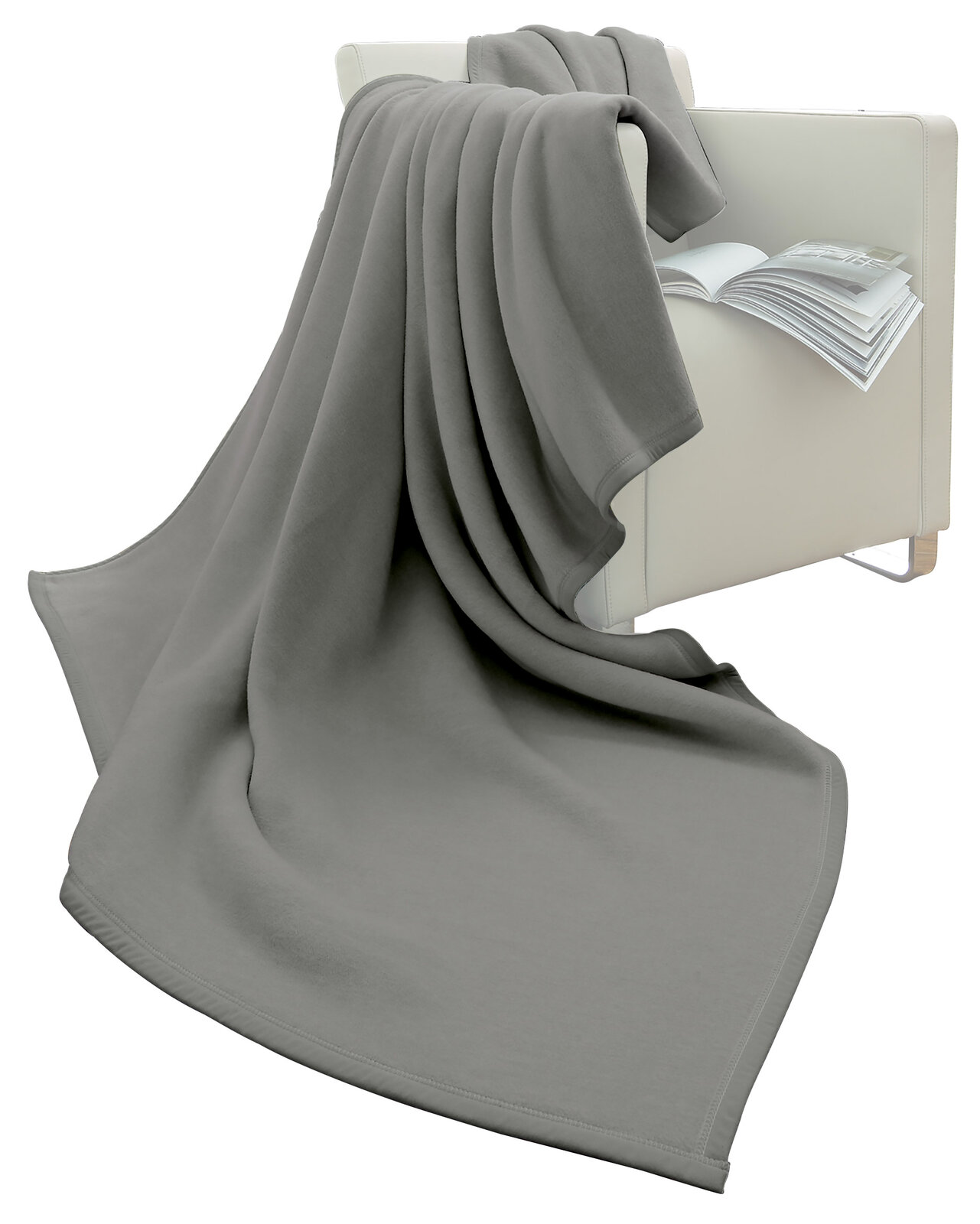 Graue Wohndecke 150 x 200 cm, drapiert über einen weißen Sessel mit einem offenen Buch, seitliche Perspektive
