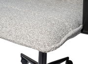 Nahaufnahme eines gepolsterten Drehstuhlsitzes mit hellgrauem Stoffbezug und schwarzem Metallgestell, seitliche Perspektive.