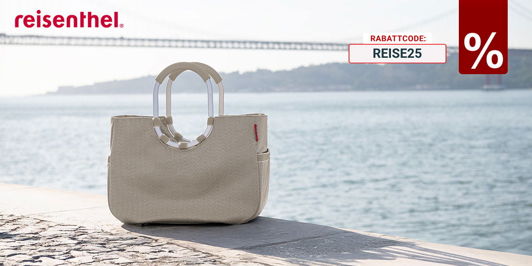 Beige Reisenthel-Tasche am Ufer vor Wasser und Brücke, Logo rechts im Bild