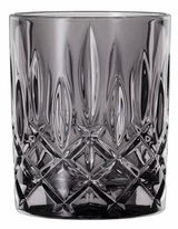 Nahaufnahme eines Whiskybechers aus Glas mit rauchigem Design und facettiertem Muster.