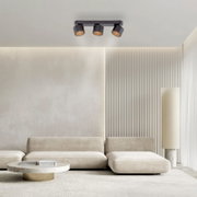 Moderne LED-Deckenleuchte mit drei verstellbaren Spots in einem stilvollen Wohnzimmer, Perspektive von unten.