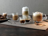Espressoglas-Set mit zwei doppelwandigen Gläsern, gefüllt mit Espresso, auf einem Tisch von schräg oben fotografiert.