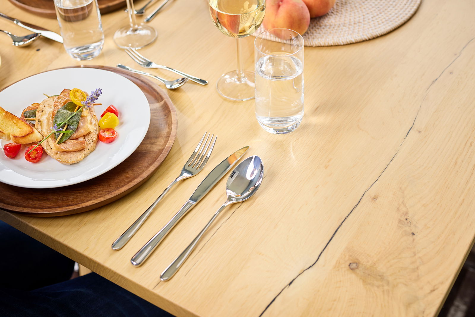 Besteck-Set Passion 30-tlg. auf einem gedeckten Tisch mit Teller, Glas und Besteck aus der Vogelperspektive