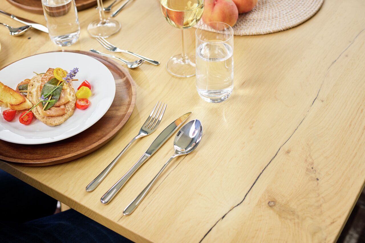 Besteck-Set Passion 30-tlg. auf einem gedeckten Tisch mit Teller, Glas und Besteck aus der Vogelperspektive