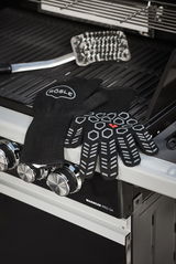 Schwarze Premium Grillhandschuhe mit rutschfestem Muster, auf einem Grill liegend, seitliche Perspektive.