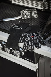 Schwarze Premium Grillhandschuhe mit rutschfestem Muster, auf einem Grill liegend, seitliche Perspektive.