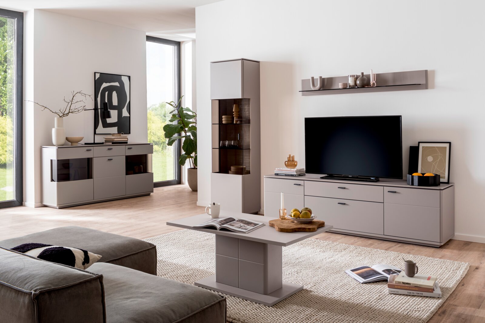 Modernes Wohnzimmer mit grauer Wohnwand (TV-Lowboard, Sideboard, Vitrine und Wandregal) sowie passendem Couchtisch; frontale Perspektive auf das Möbel-Set