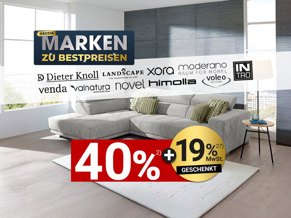 Modernes Wohnzimmer mit grauem Ecksofa, Kissen, Teppich und Markenhinweis „Große Marken zu Bestpreisen
