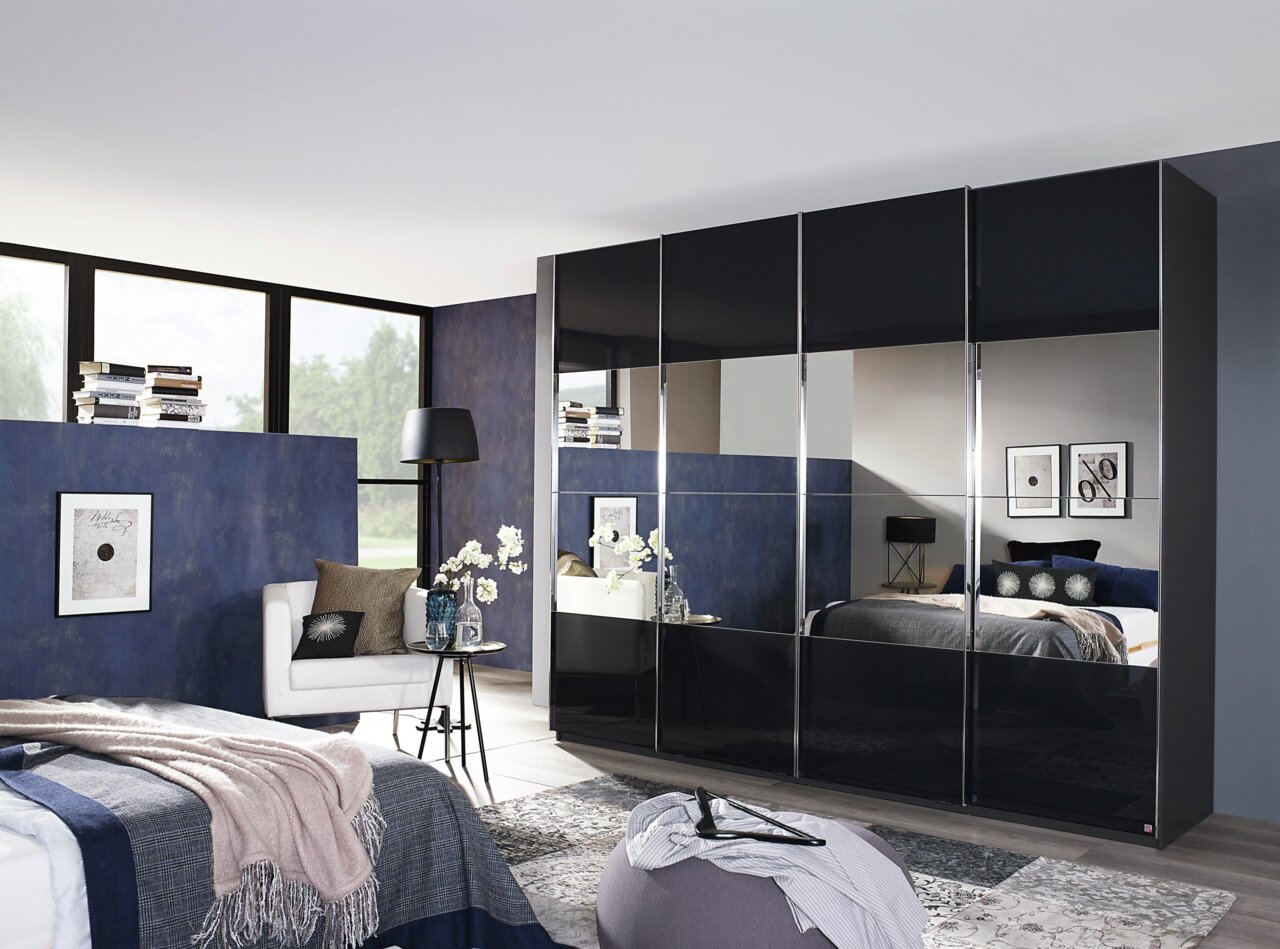 Novel Kast met zweefdeuren SALIGO Moderne hangdeurkast met een zwart hoogglans oppervlak en spiegels, zijaanzicht in een stijlvolle slaapkamer.