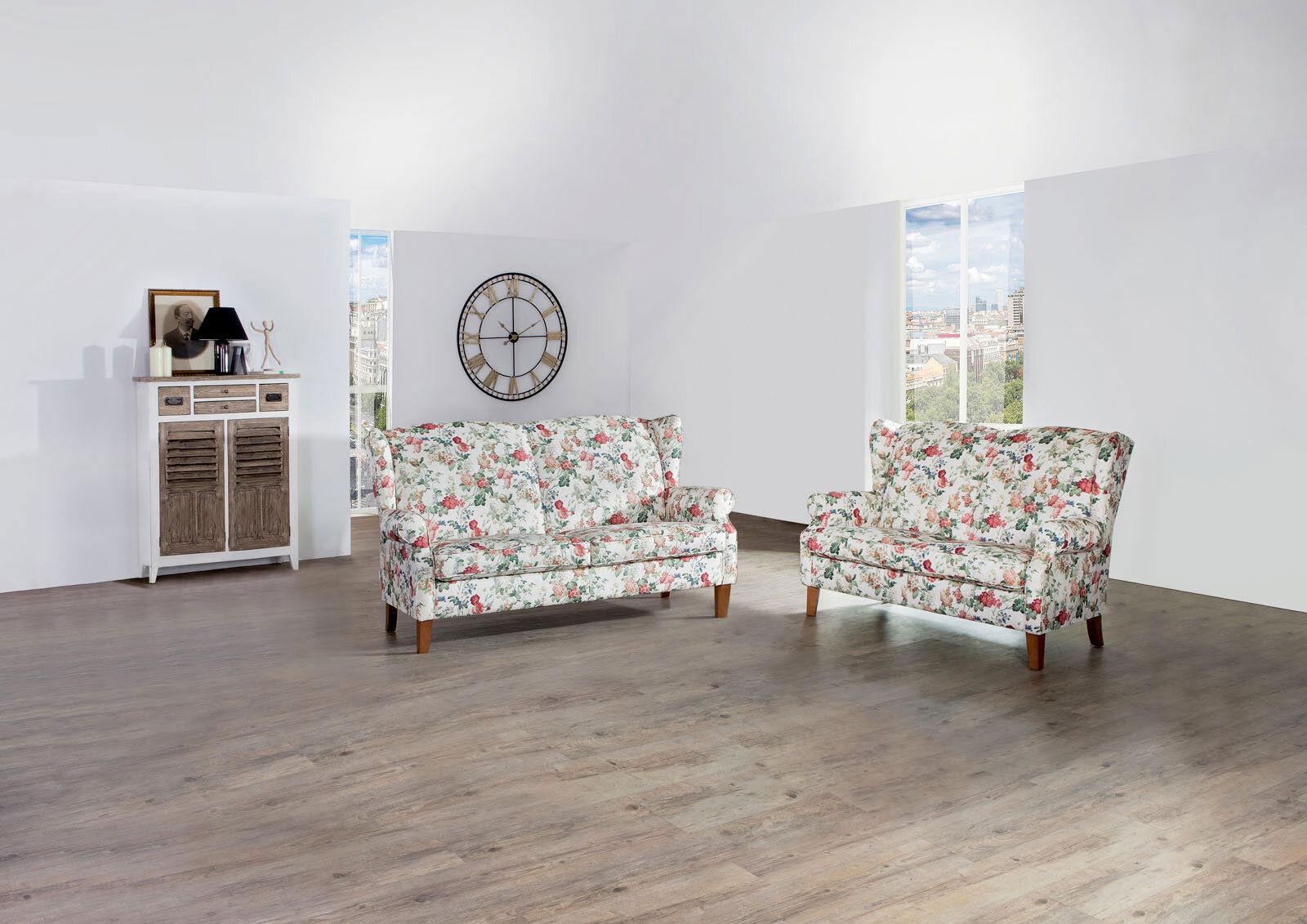 Zwei Sofabänke der Serie KIMBERLY mit floralem Muster in einem hellen Raum, seitliche Perspektive.