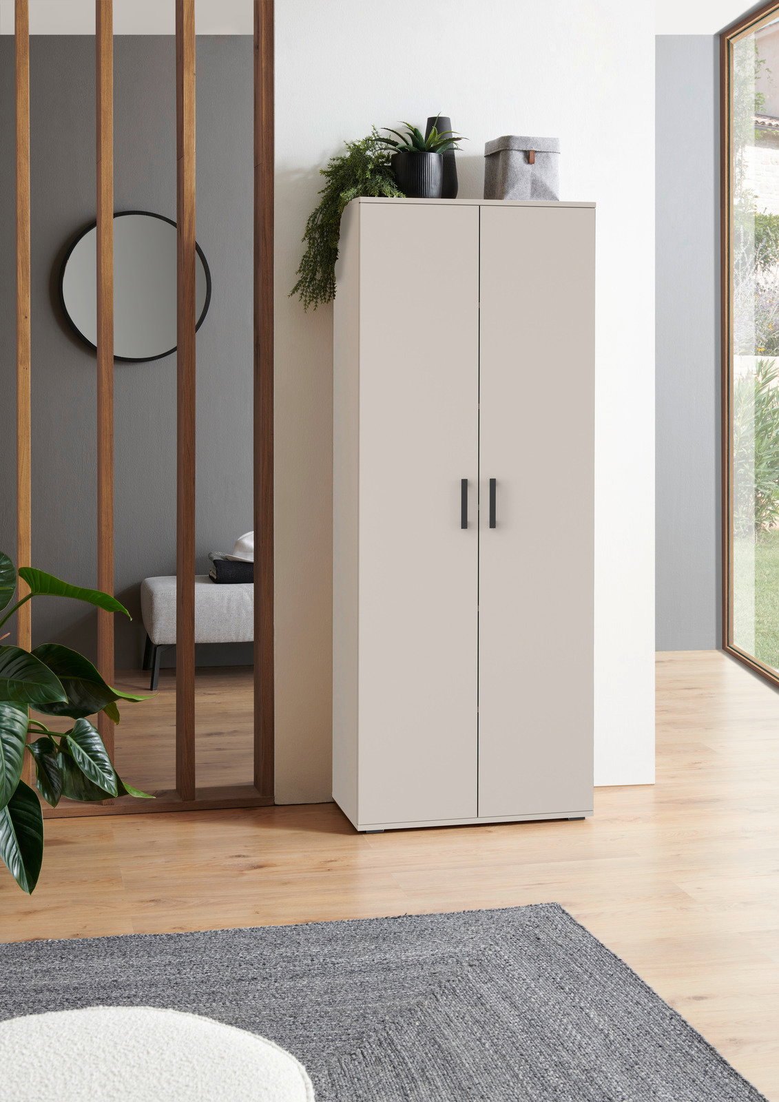 XORA XL-Schuhschrank ALEX Moderner XL-Schuhschrank in heller Farbe, frontal fotografiert, mit Pflanzen und Dekoration auf der Oberseite, in einem stilvollen Raum mit Holzboden und großen Fenstern.