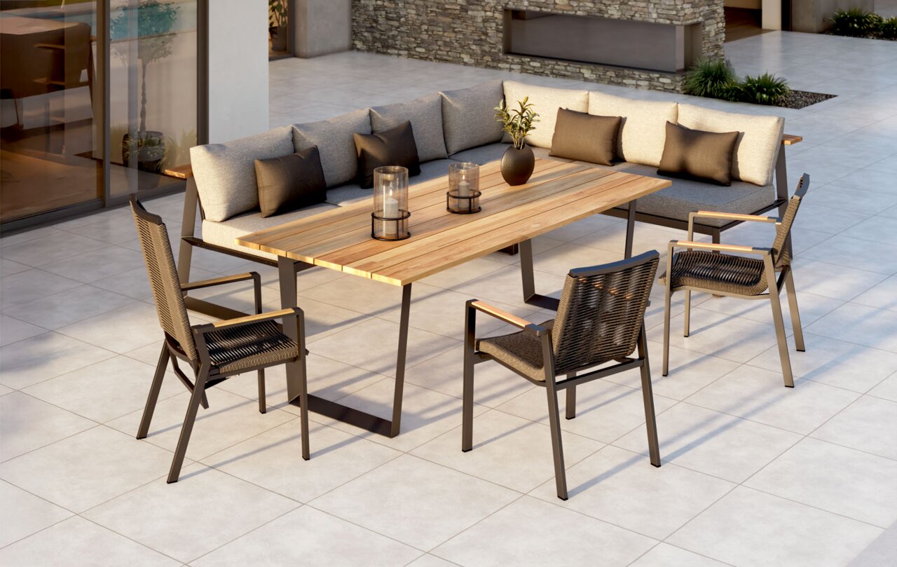 Amatio Relaxfauteuil LA SPEZIA Moderne loungeset en eetset op een terras: L-vormige hoekbank met lichte bekleding en kussens, grote houten tafel met metalen onderstel en drie rieten stoelen; gefotografeerd vanuit een schuin vooraanzicht van bovenaf.