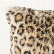 Nahaufnahme eines flauschigen Kissens mit Leopardenmuster, perspektivisch von der Seite aufgenommen.