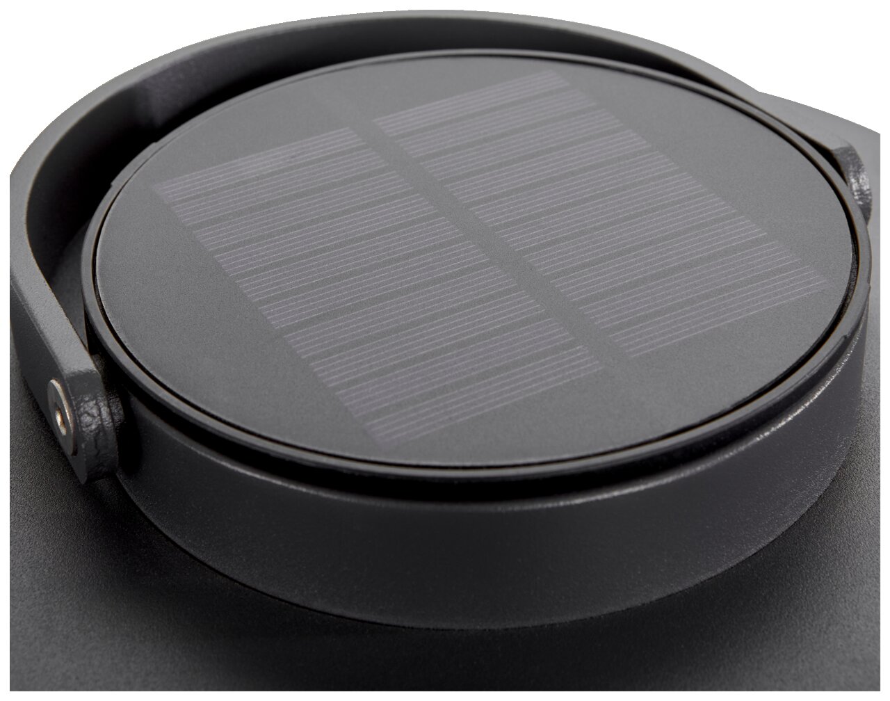 Nahaufnahme einer runden Solarlampe mit schwarzem Gehäuse und sichtbarem Solarpanel von oben.