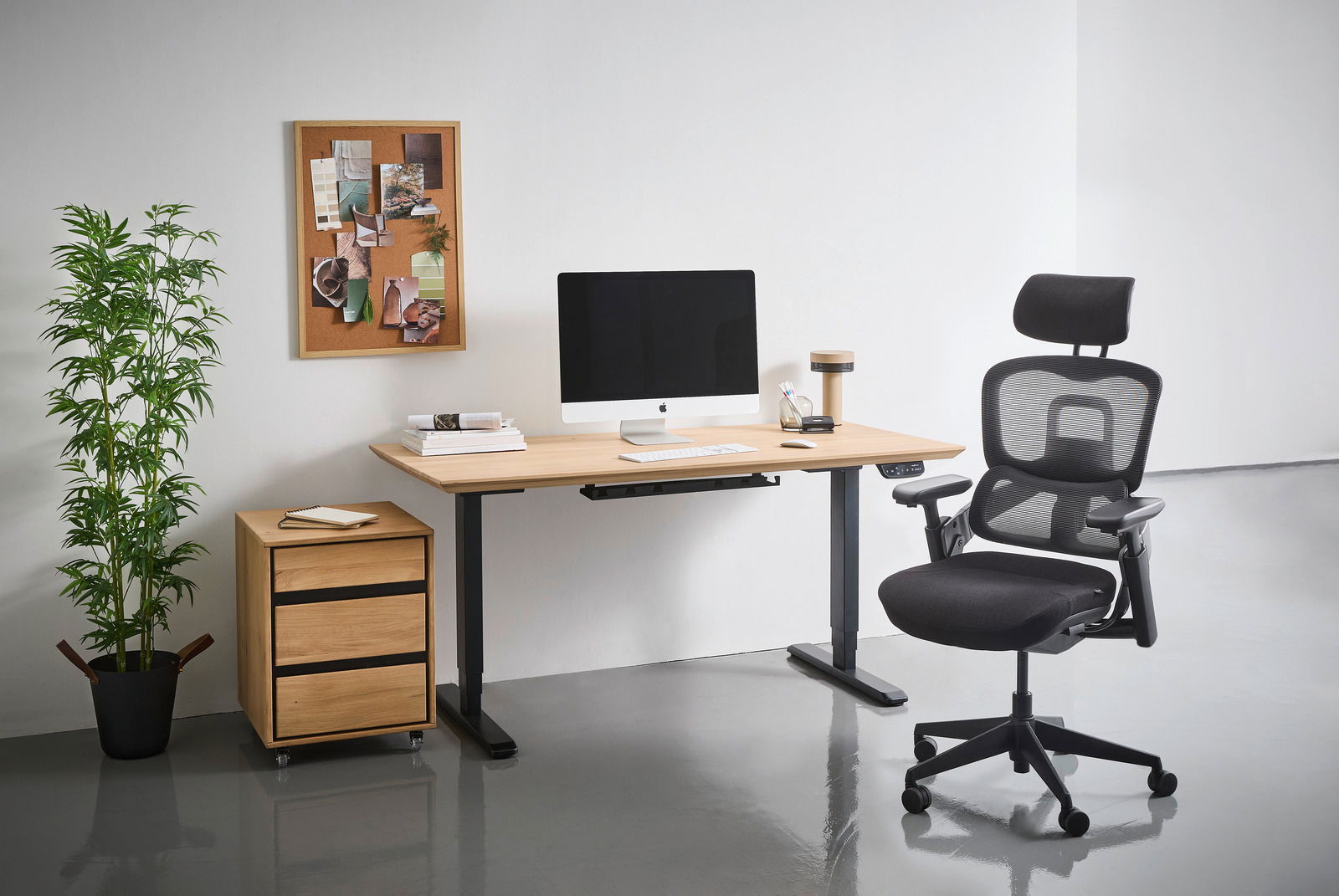 Moderner E-Schreibtisch 180cm mit Holzoberfläche, schwarzem Gestell, ausgestattet mit Computer und Büromaterialien, seitliche Perspektive