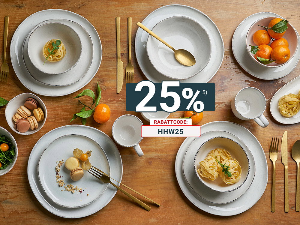 Modernes cremeweißes Geschirr mit goldfarbenem Besteck auf rustikalem Holztisch dekoriert. Stilvolle Tischdekoration mit Pasta, Macarons und frischen Mandarinen