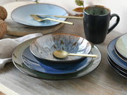 Kombiservice Bali 16-tlg. in Nahaufnahme, bestehend aus Tellern, Schalen und einer Tasse in verschiedenen Blautönen mit goldfarbenem Besteck auf einem Holztisch.