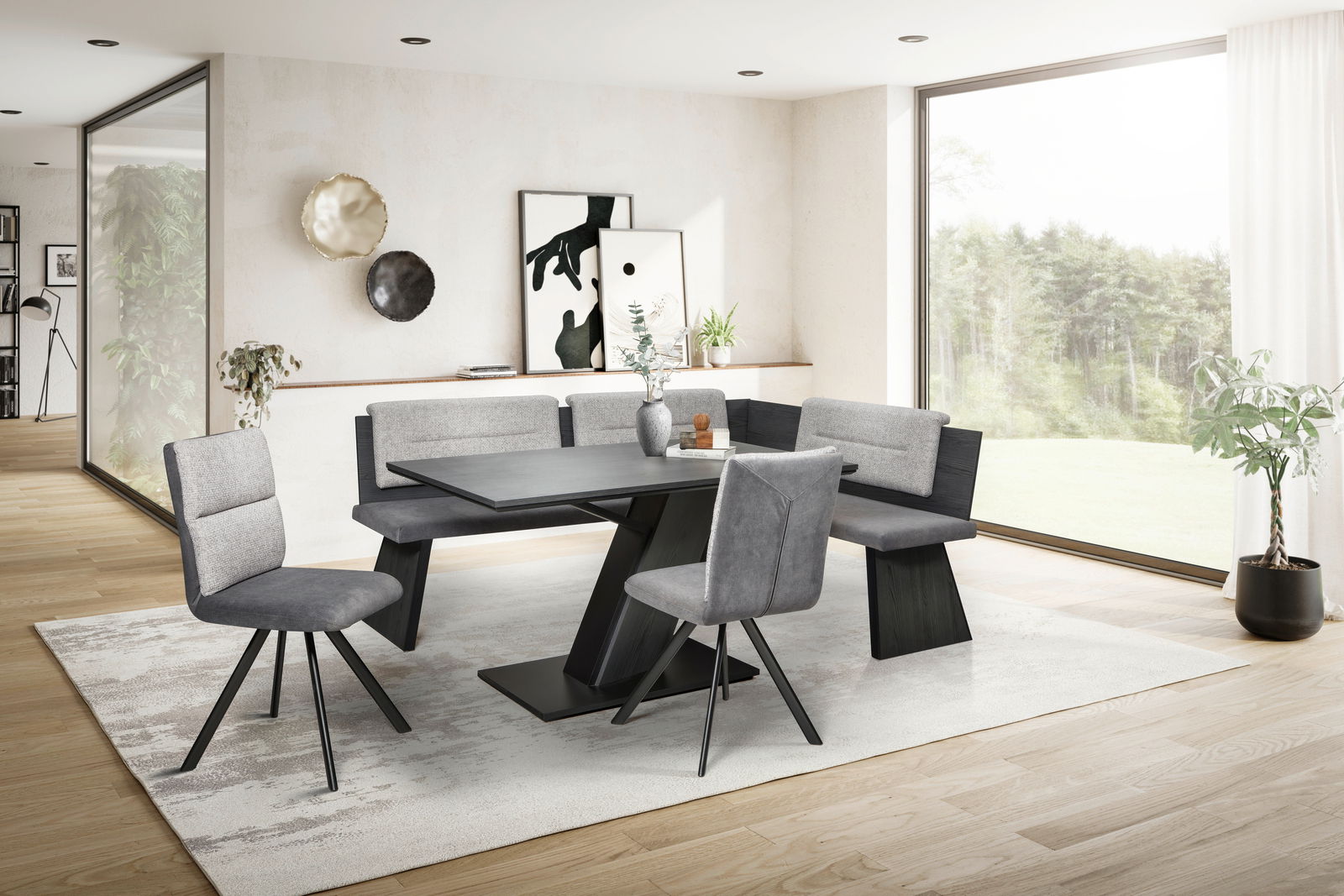 Moderne Eckbankgruppe in einem hellen Wohnzimmer mit großen Fenstern, bestehend aus einem Tisch, einer Eckbank und zwei Stühlen in grauen Tönen, seitliche Perspektive.
