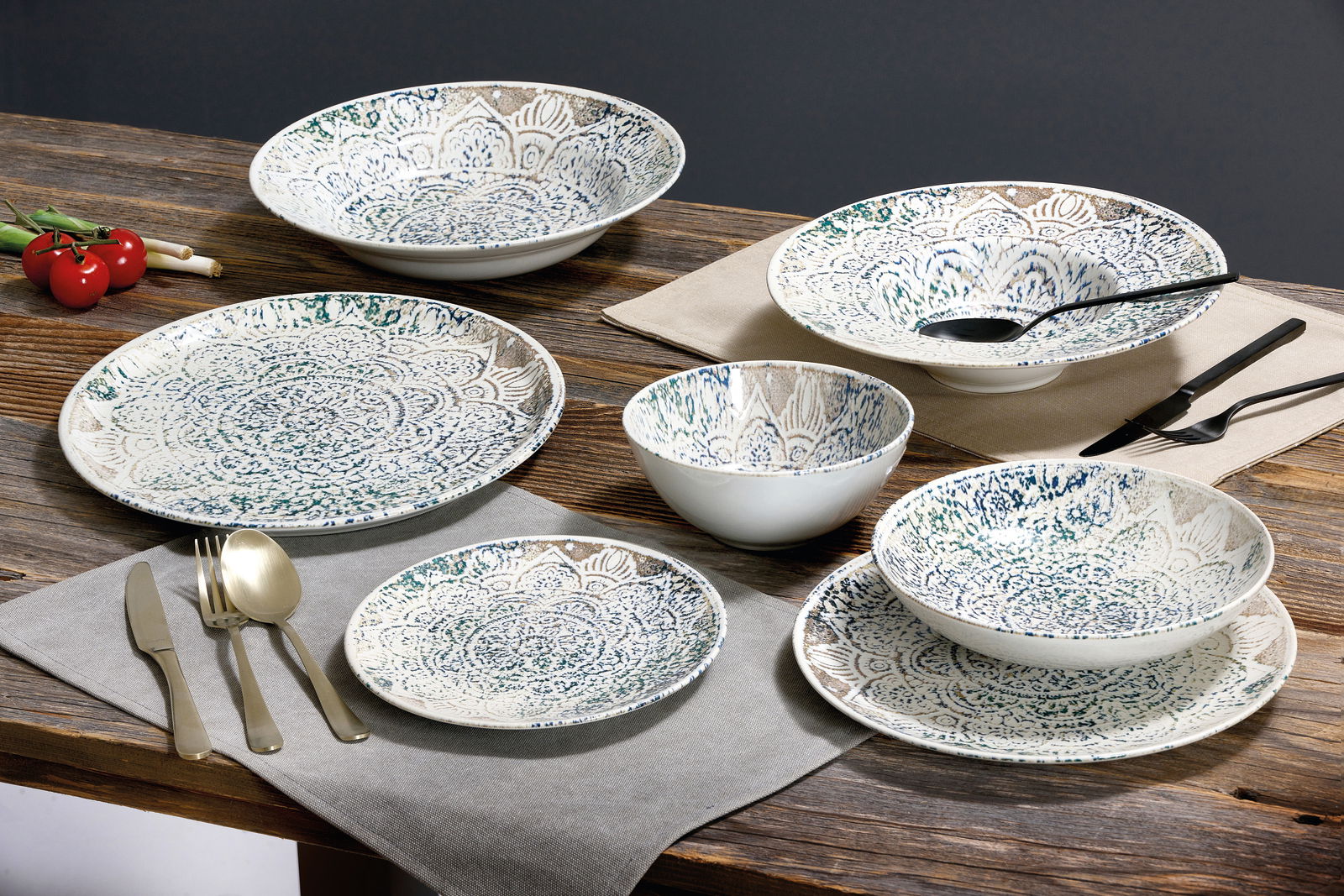 Ritzenhoff & Breker Tafelservice 18-tlg. LUIGI Tafelservice 18-tlg. mit dekorativem Muster, bestehend aus Tellern und Schalen, auf einem Holztisch arrangiert, seitliche Perspektive