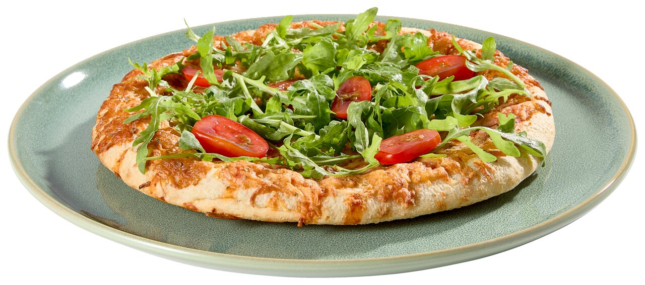 Schuin van voren gefotografeerde pizza met rucola en gehalveerde cherrytomaten op een groen keramisch bord