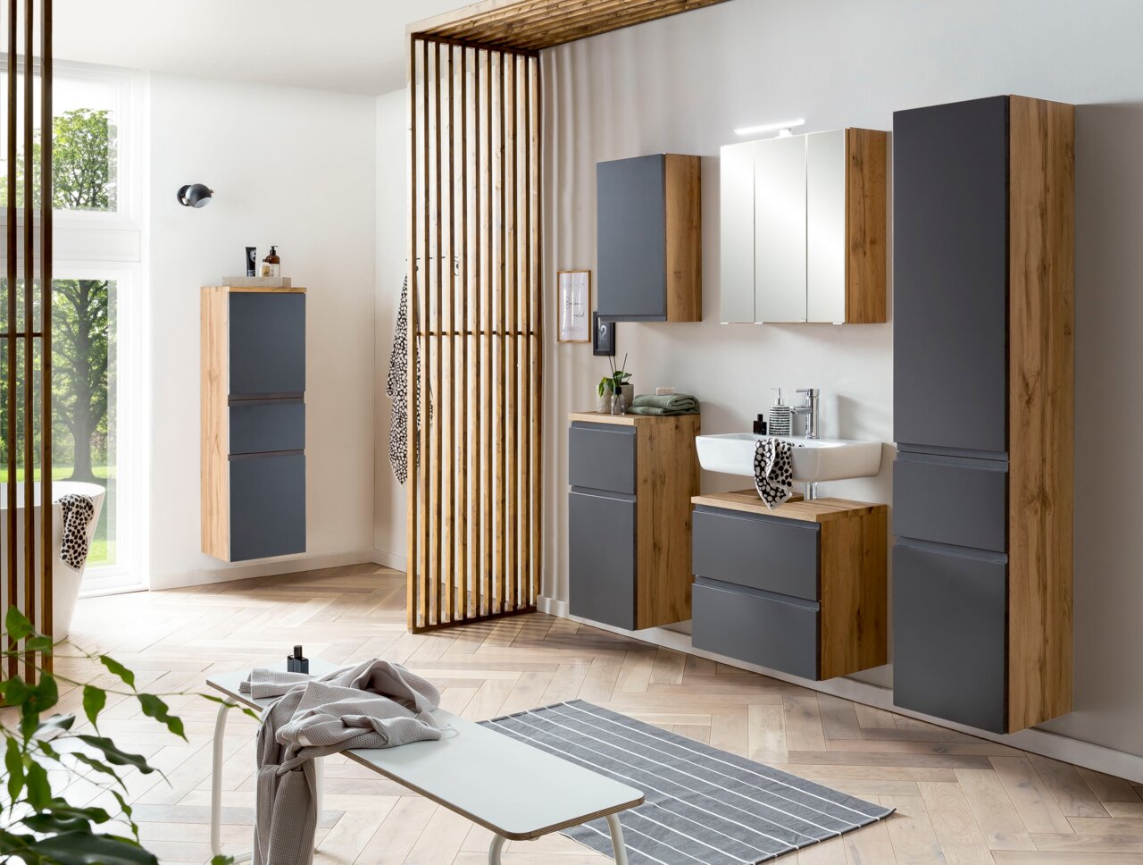 Moderner Waschbeckenunterschrank in Holzoptik mit grauen Fronten, Teil eines stilvollen Badezimmerschranksystems, aus der Frontalperspektive fotografiert.