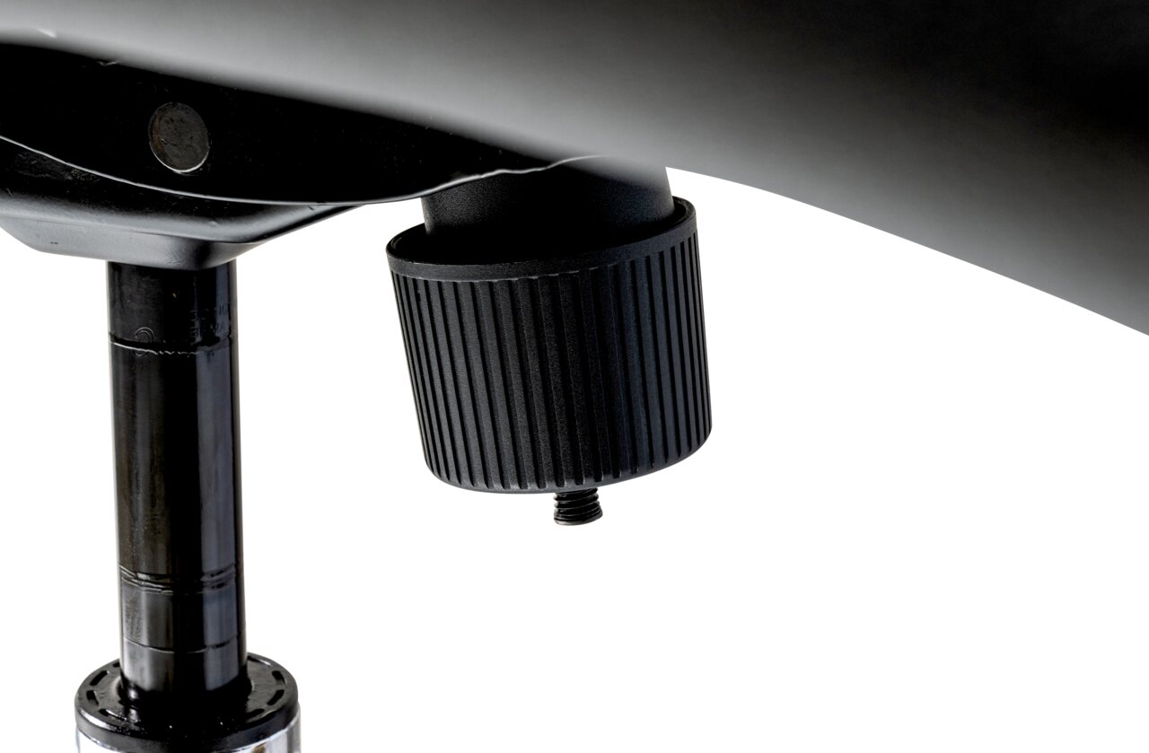 Nahaufnahme eines schwarzen Drehknopfes unter einem Chefsessel, seitliche Perspektive