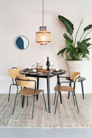 Esszimmer mit modernem Stuhl-Set aus Holz und Metall, runder Tisch, hängende Lampe und große Pflanze, seitliche Perspektive