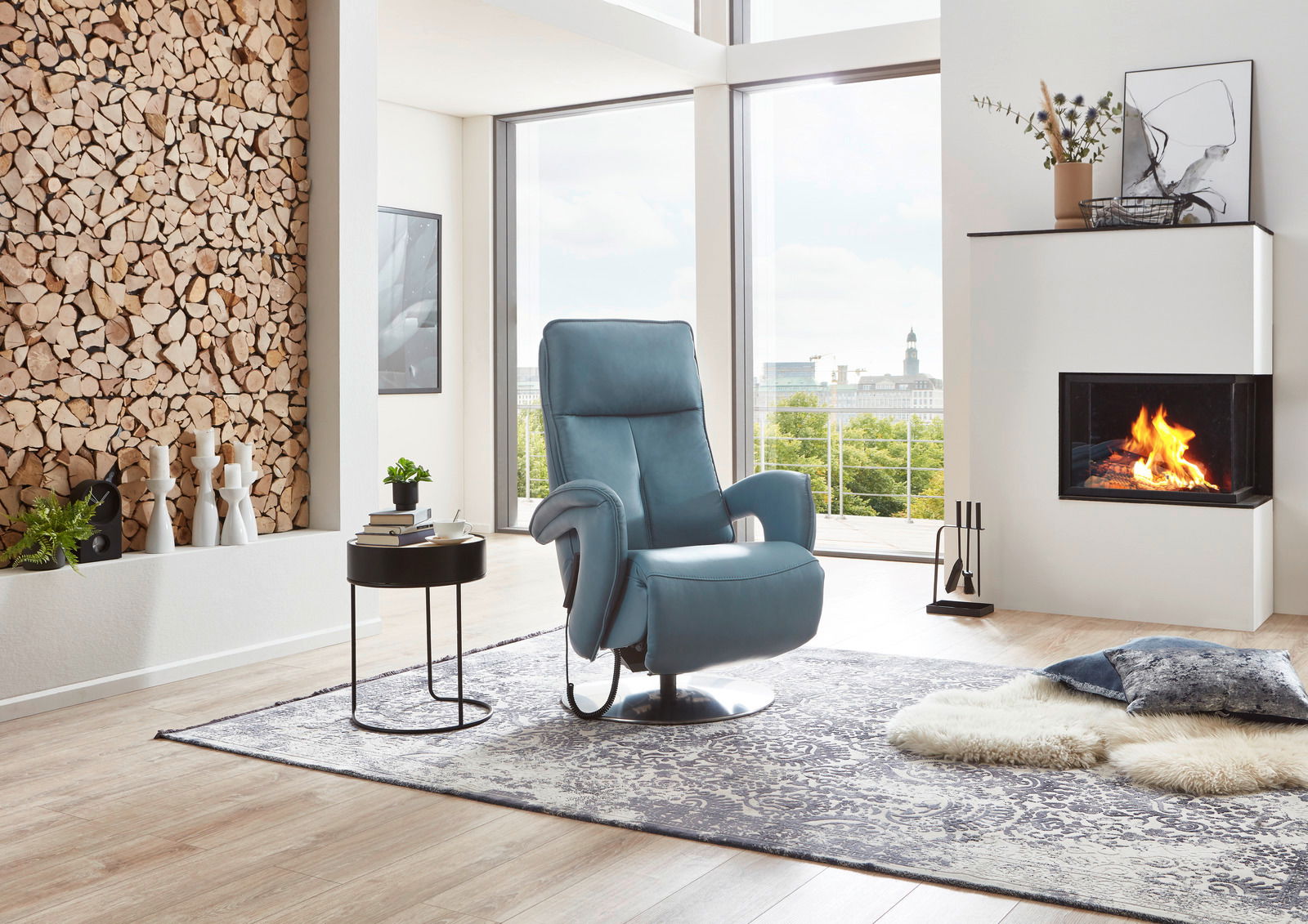 Moderner blauer Relax-Sessel in einem stilvollen Wohnzimmer mit Kamin und Panoramafenster, seitliche Perspektive.