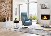 Moderner blauer Relax-Sessel in einem stilvollen Wohnzimmer mit Kamin und Panoramafenster, seitliche Perspektive.