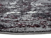 Nahaufnahme eines Designer-Teppichs mit grauen, weißen und roten Mustern, seitliche Perspektive