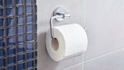 Toilettenpapierrolle auf einem modernen, verchromten Halter an einer Badezimmerwand, seitliche Perspektive