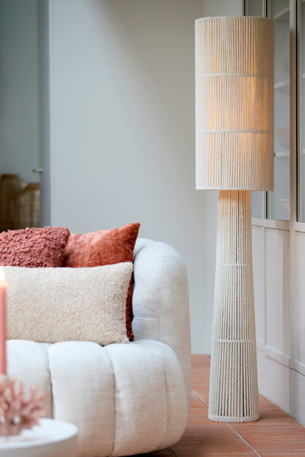 Stehleuchte mit texturiertem, zylindrischem Lampenschirm in einem modernen Wohnzimmer, seitliche Perspektive