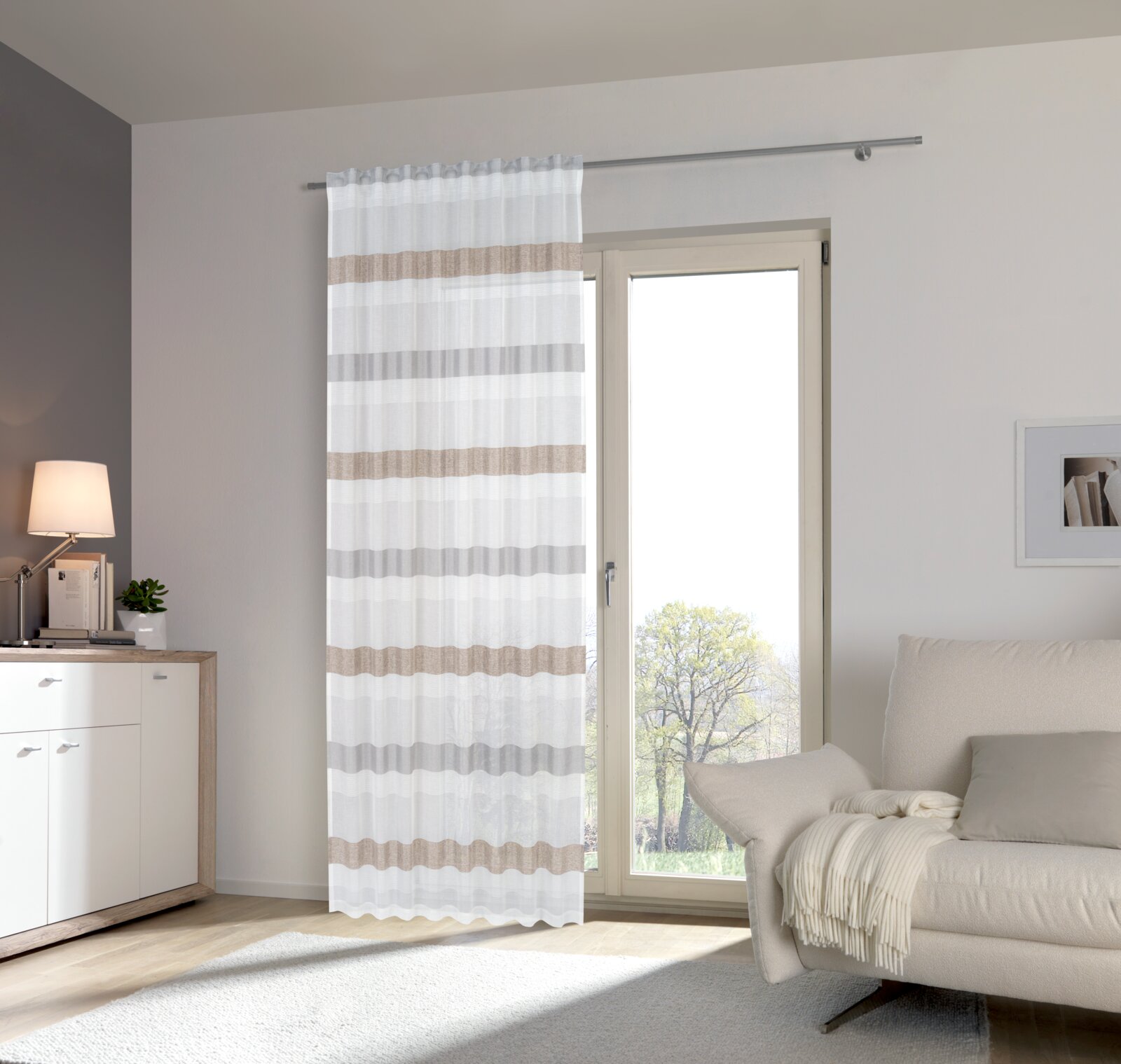Fertigvorhang mit horizontalen Streifen in Beige und Grau, aufgehängt vor einer Glastür in einem modernen Wohnzimmer. Perspektive von vorne.