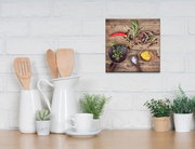 Leinwandbild mit Kräutern der Provence, aus der Perspektive einer Küchenarbeitsplatte betrachtet, zeigt Gewürze und Kräuter auf Holzlöffeln vor einer weißen Ziegelwand.