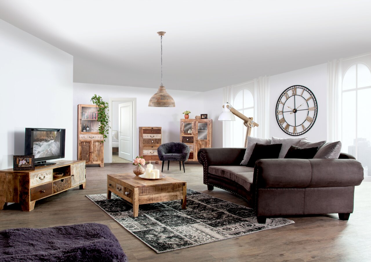 Rustikaler Couchtisch aus Holz in einem gemütlichen Wohnzimmer, frontal von oben betrachtet.