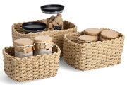 Dreiteiliges Aufbewahrungskorb-Set aus geflochtenem Material, gefüllt mit Gläsern und Behältern, aus der Vorderansicht.