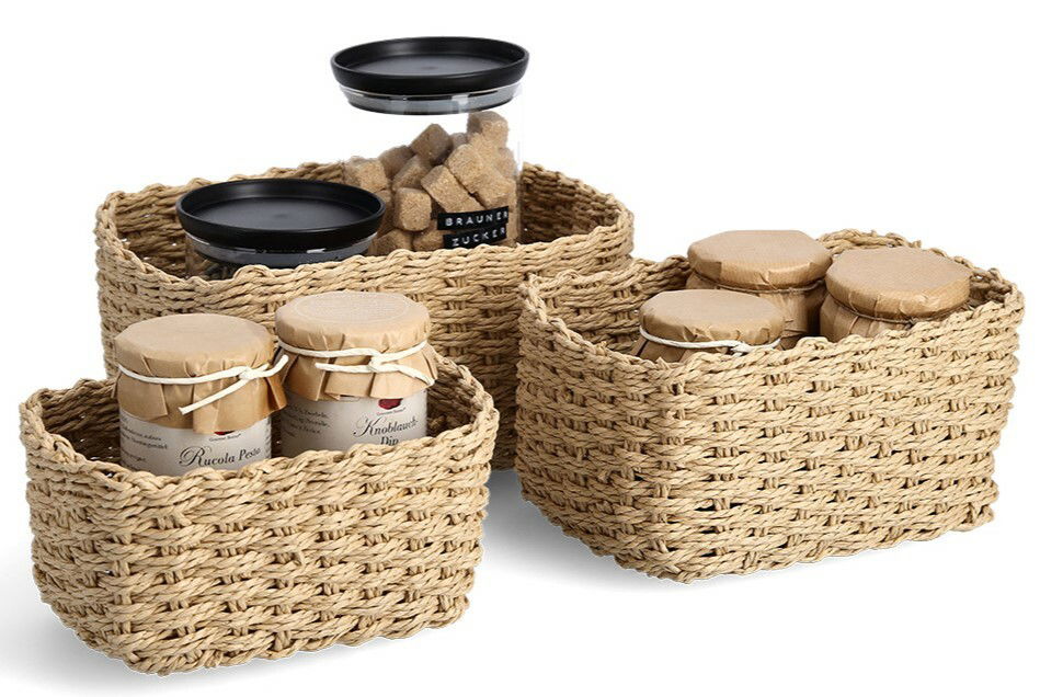 Dreiteiliges Aufbewahrungskorb-Set aus geflochtenem Material, gefüllt mit Gläsern und Behältern, aus der Vorderansicht.