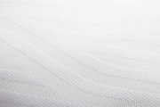 Nahaufnahme eines weißen, strukturierten Schlafkissens in 80 x 40 cm Größe.
