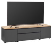TV-Lowboard in moderner Frontansicht mit Holzoberfläche und dunklen Schubladen, darauf steht ein großer Flachbildfernseher.