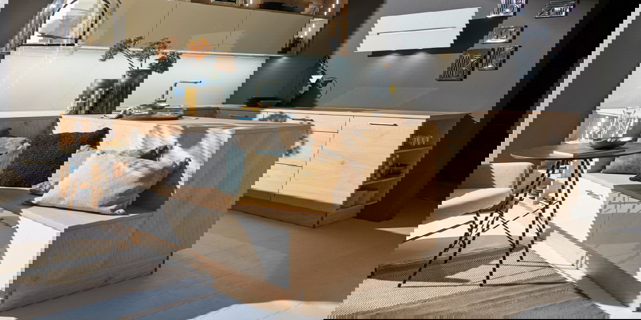 Die Küche ist aus hellem Holz und hat eine gemütliche Sitzecke