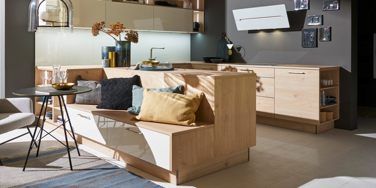 Die Küche ist aus hellem Holz und hat eine gemütliche Sitzecke