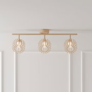 Beige Deckenleuchte mit drei Spot-Schirmen im dekorativen Blätter-Design an einer geraden Schiene, eingeschaltet, Frontansicht leicht von unten