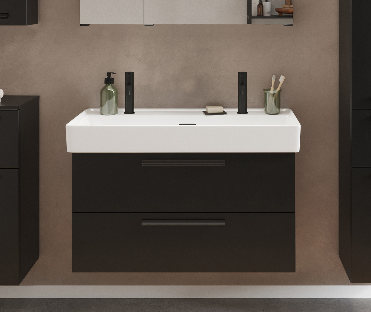Frontale Ansicht eines modernen Waschtisch-Sets mit zwei schwarzen Armaturen, einem weißen Waschbecken und einem dunklen Unterschrank.
